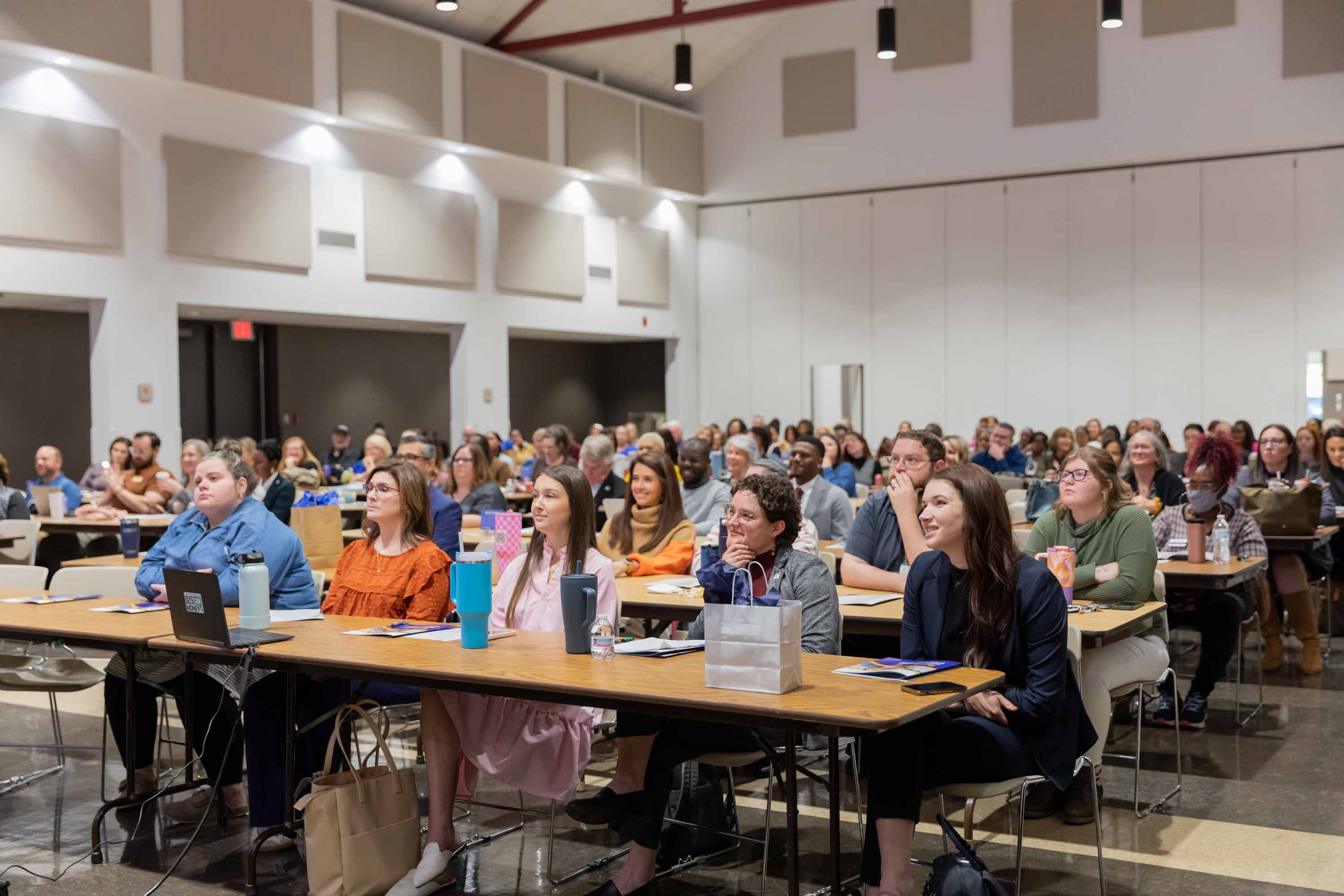 A room of attendees listening at the ALICE Summit