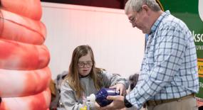 A girl learning how to use a bag valve mask.