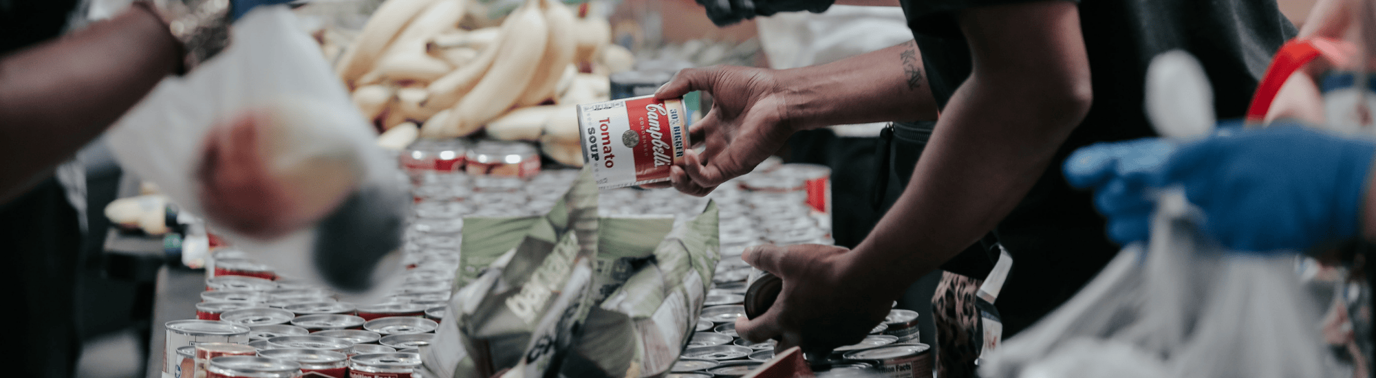 A man is handing out a can of food.