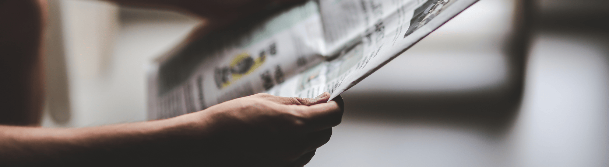 A person is holding the newspaper.