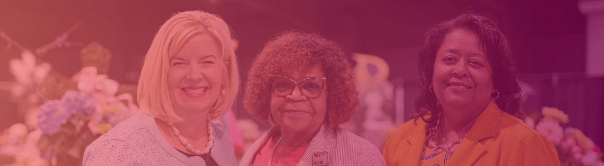 Three women are smiling at the First Ladies' Luncheon